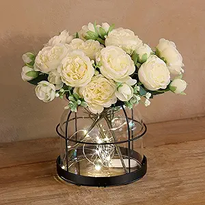 Vintage-style glass vase with rustic lantern design, decorated with plants, flowers, and string lights for farmhouse home decor.